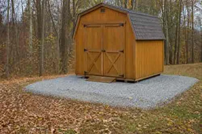 Wooden shed on a level gravel base with clear drainage in autumn