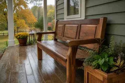Maintained wooden porch bench with rain droplets during early fall