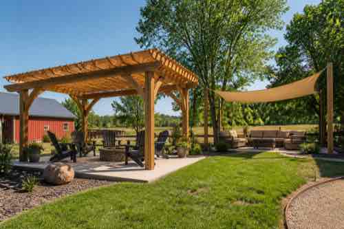How Do You Choose Shade for a Sunny Backyard? Pergola and shade sail options in a sunny rural backyard