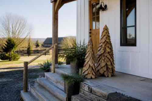 How Do You Choose Outdoor Décor That Fits a Rural Property? Handcrafted wood decor at a rural farmhouse entry